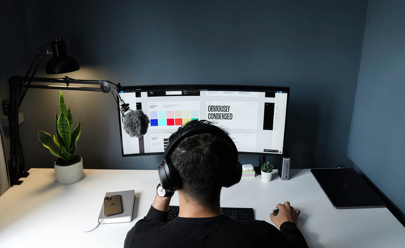 A one-person business owner wearing headphones and sitting at a computer, working on tasks for various reasons.