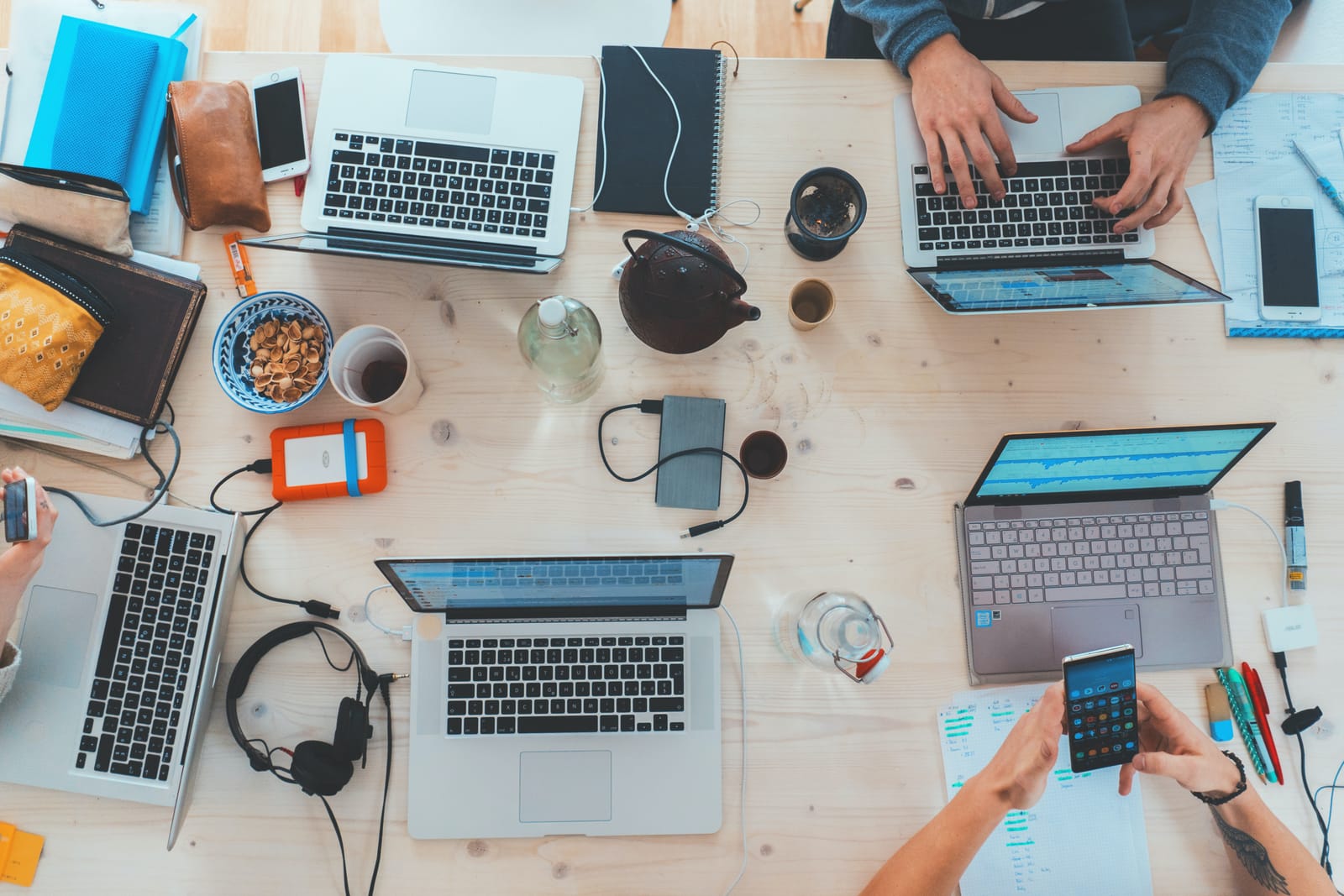 table with laptops and phones on