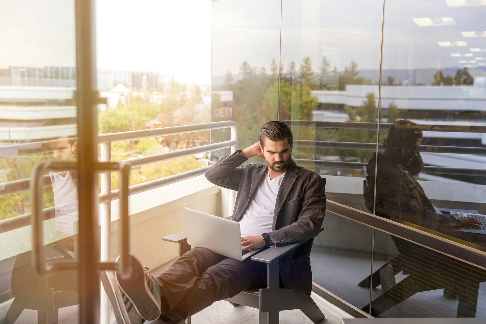 A man sitting in a chair and using a laptop.