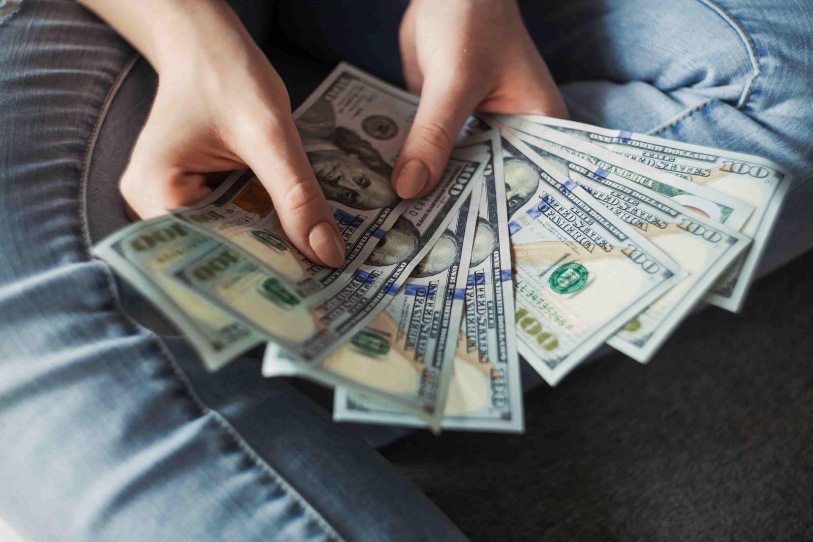 A woman is holding a bunch of money in her hands.