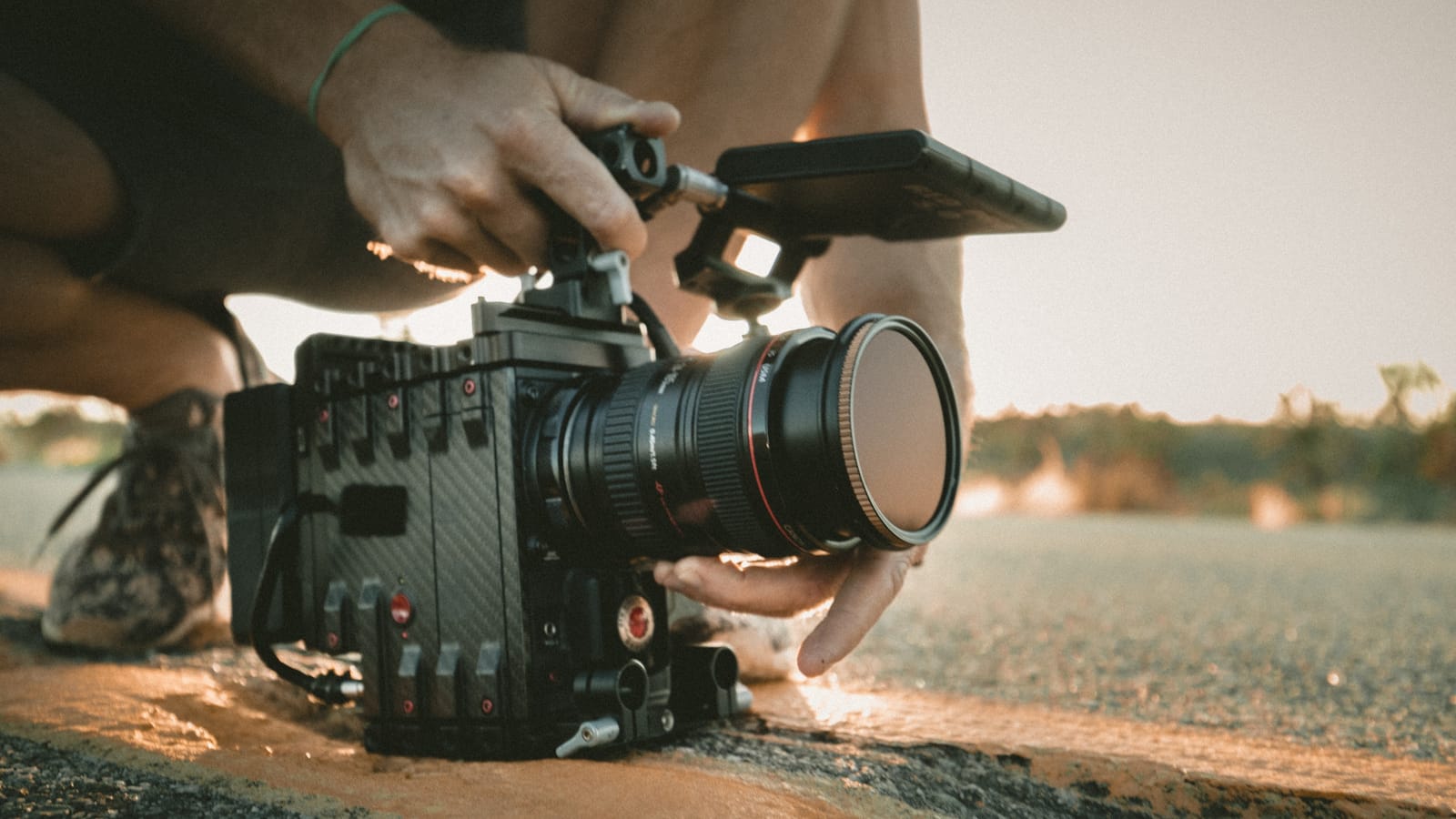 man knelt down with video camera