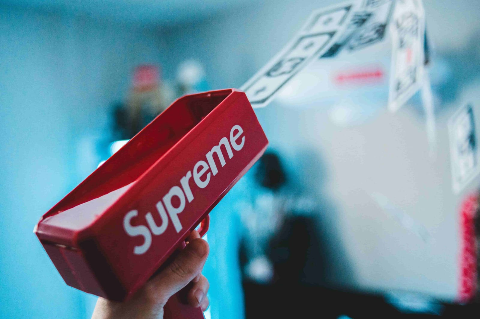 supreme money gun shooting dollar bills into the air