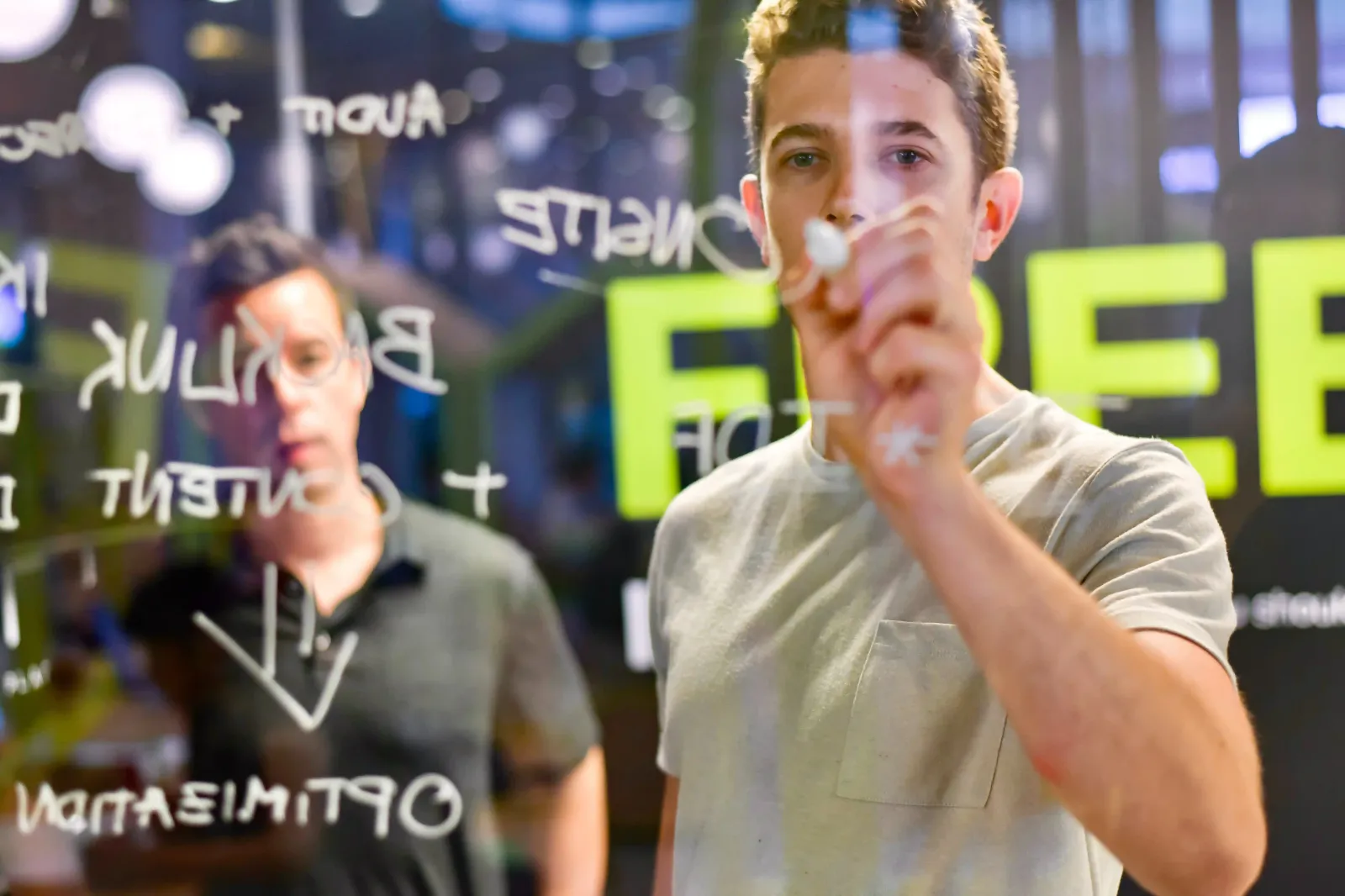 A man is illustrating inbound marketing on a glass wall.