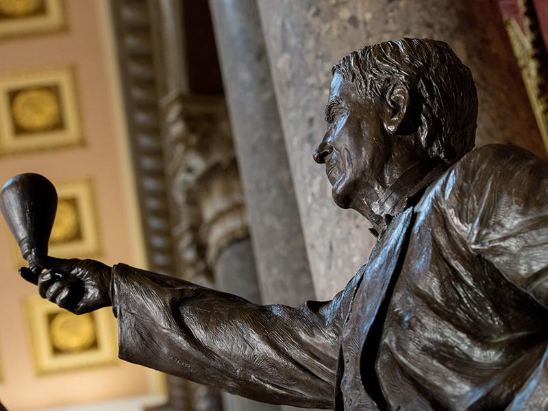 A statue of Thomas Edison holding a lightbulb.