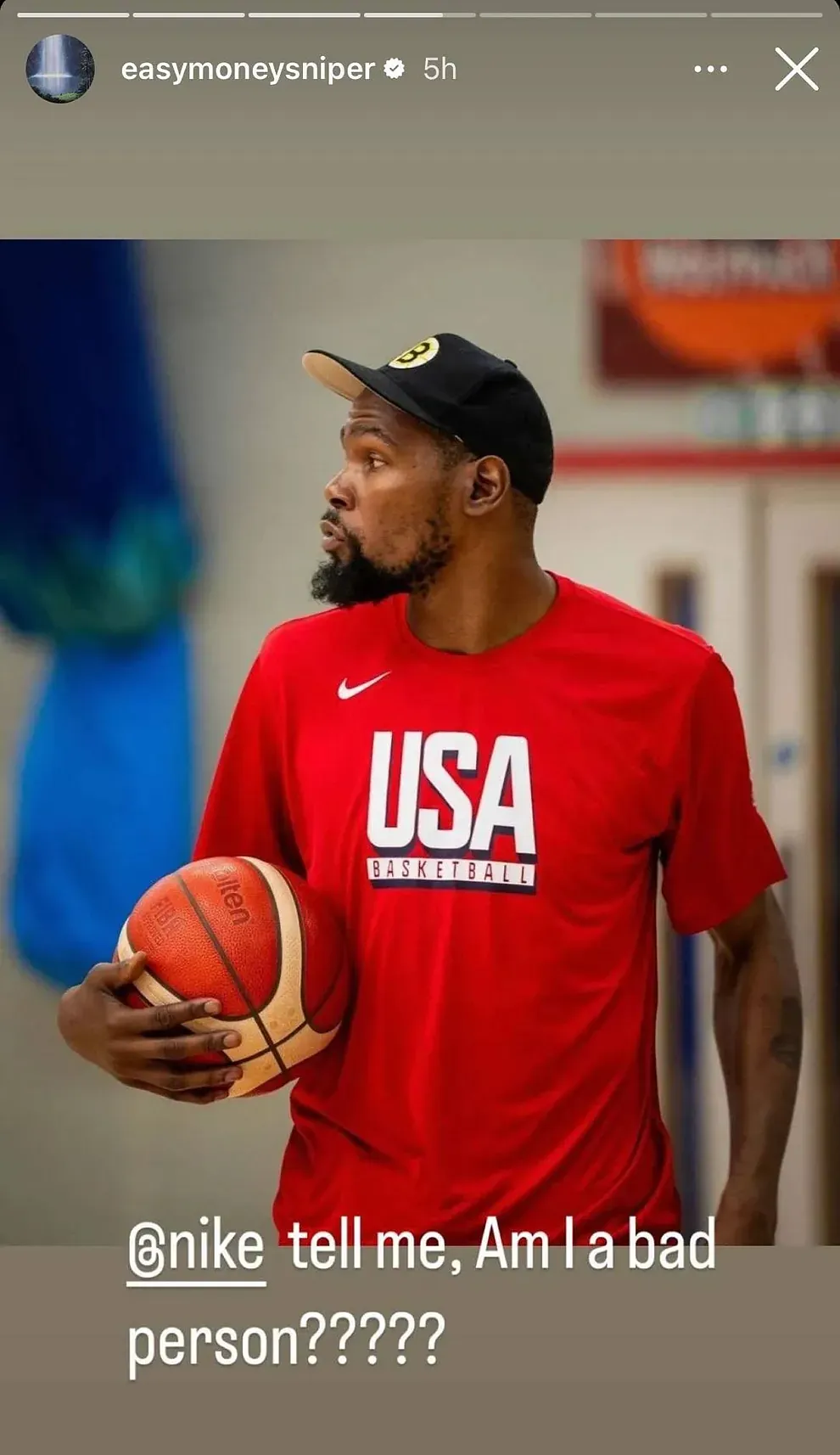 A man wearing a red USA Basketball shirt and a black cap holds a basketball, next to the text "@nike tell me, Am I a bad person?????.