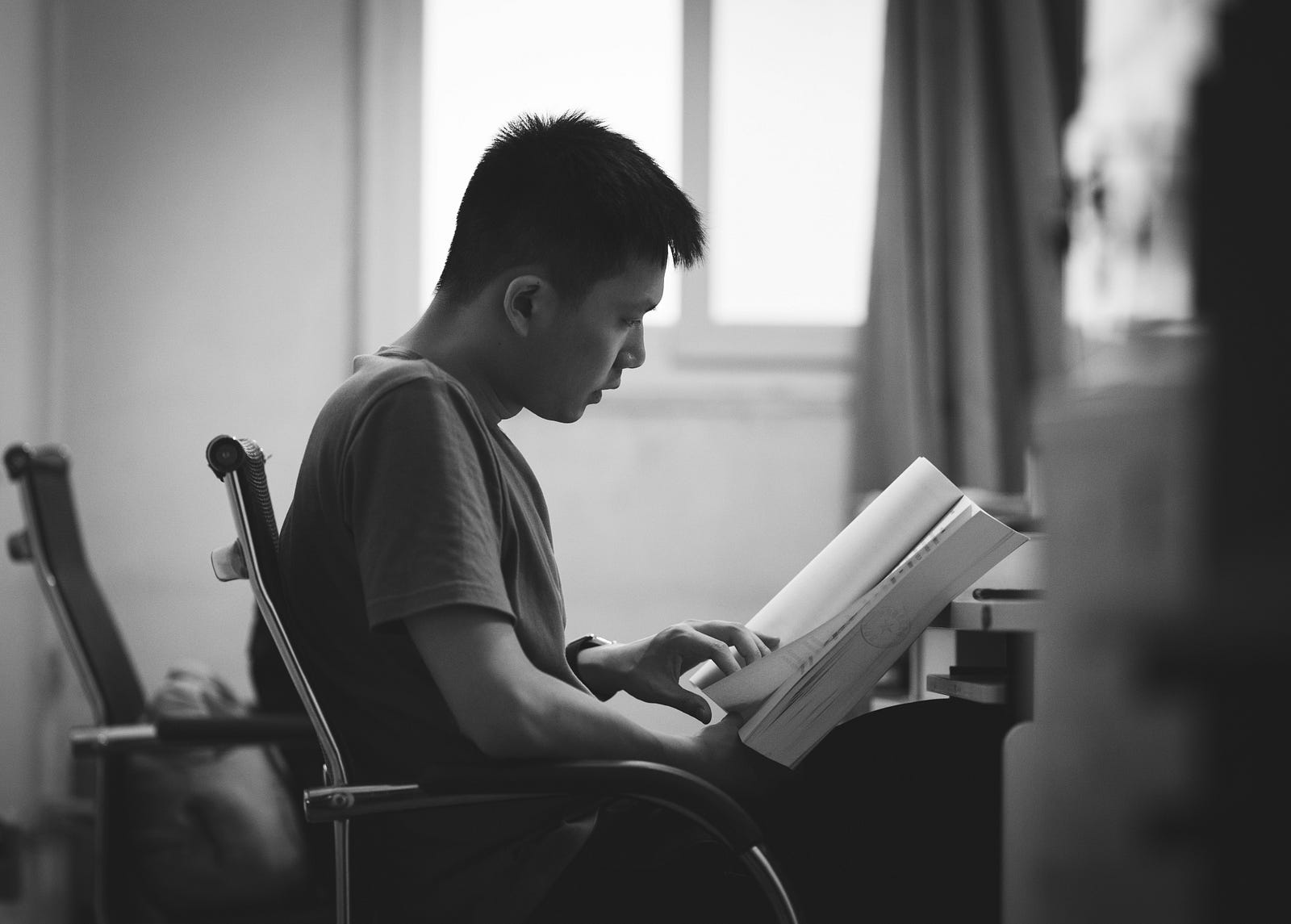 A entrepreneur sitting in a chair reading a book.